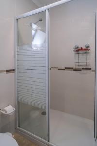 une douche avec une porte vitrée dans une salle de bain dans l'établissement Casa da Tia, à Luz