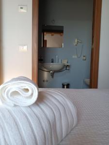 a white towel laying on top of a bed at CASAL MICELIO in Udine