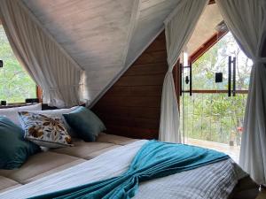 a bedroom with a bed with a canopy and a window at Cabana Violeta in Visconde De Maua