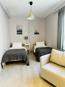 1 dormitorio con 2 camas y sofá en 6 Hane Üsküdar Serviced Apartments en Estambul
