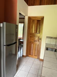 cocina con nevera y puerta de madera en Hotel Villas Vilma en Fortuna