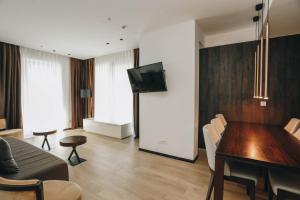 a living room with a dining room table and a television at Beachfront luxury apartment in Budva