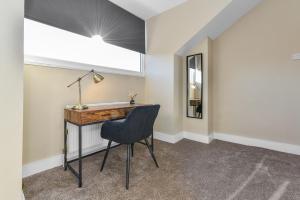 a desk and a chair in a room with a window at Haydn House Luxurious Retreat - 4 bedroom, 10 guest max, Perfect home away from home in Nottingham