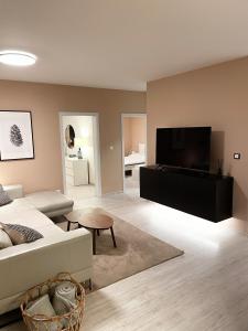 Luxury Apartments Panorama في دونوفالي: غرفة معيشة مع أريكة وتلفزيون بشاشة مسطحة
