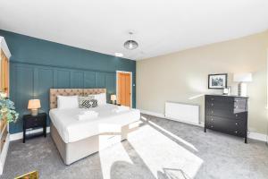 a bedroom with a white bed and a blue wall at Haydn House Luxurious Retreat - 4 bedroom, 10 guest max, Perfect home away from home in Nottingham