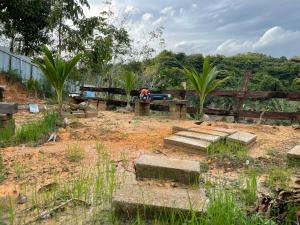 a garden with concrete steps and a wooden fence at Papadam Bamboo House in Bintulu