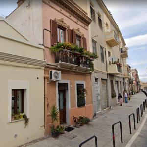 une rue étroite avec un bâtiment doté d'un balcon dans l'établissement Suite 332, à Cagliari