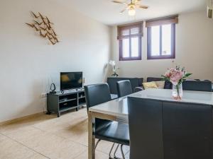 a living room with a table and chairs and a tv at Apartment La Cala Boulevard in La Cala de Mijas