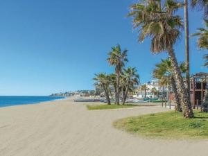 una playa de arena con palmeras y el océano en Apartment La Cala Boulevard en La Cala de Mijas