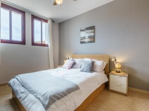 a bedroom with a large bed and two windows at Apartment La Cala Boulevard in La Cala de Mijas