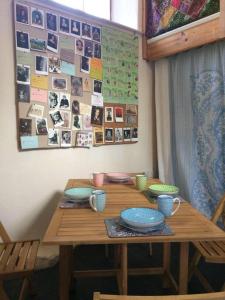 a wooden table with plates and cups on it at The Studio, Trelugga in Helston