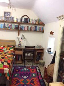 a bedroom with a bed and a desk with books at The Studio, Trelugga in Helston