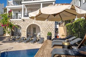 eine Terrasse mit Stühlen und einem Sonnenschirm neben einem Pool in der Unterkunft Noa Suite Hotel Only Adult in Bodrum City