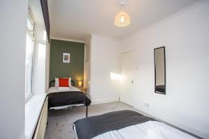 1 dormitorio con 2 camas y ventana en Roberts House by #ShortStaysAway, en Blythe