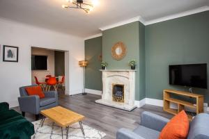 sala de estar con chimenea y TV en Roberts House by #ShortStaysAway, en Blythe