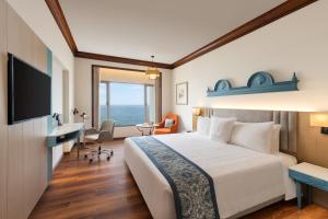um quarto de hotel com uma cama e uma televisão em Welcomhotel by ITC Hotels, Devee Grand Bay, Visakhapatnam em Visakhapatnam