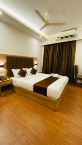 um quarto com uma cama grande e uma ventoinha de tecto em Hotel Plaza Heights em Mangalore