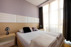 sypialnia z dużym łóżkiem i dużym oknem w obiekcie Apart K Apartments & Rooms w Belgradzie