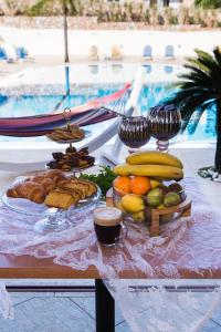 una mesa con un montón de fruta y pan. en Real Palace, en Malia