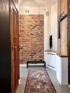 a hallway with a brick wall and a door and a rug at Uniikki&Upea Helmi ydinkeskustassa in Tampere
