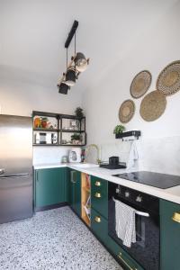 a kitchen with green cabinets and a stainless steel refrigerator at 54You in Ahuzat Barak