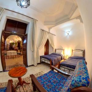 Un dormitorio con dos camas y una mesa. en Riad Dar Moulay Ali, en Marrakech