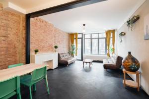 een woonkamer met een bakstenen muur en een tafel en stoelen bij Charming and Spacious Antwerp City Center Apartments in Antwerpen