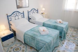 a bedroom with two beds with towels on them at Talè Talè Apartment in Marina di Ragusa +36 photos