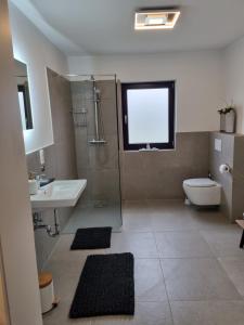a bathroom with a sink and a toilet and a window at Ferienwohnung Irina in Zülpich +14 photos