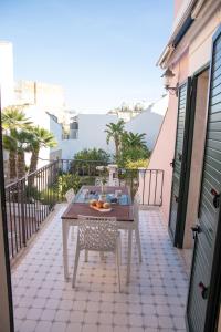 a patio with a table and chairs on a balcony at Talè Talè Apartment in Marina di Ragusa