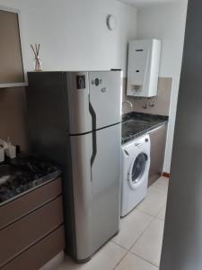 a kitchen with a refrigerator and a washing machine at Gaudium in Paraná