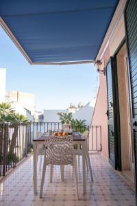 a balcony with a table with fruit on it at Talè Talè Apartment in Marina di Ragusa