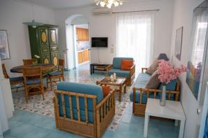 a living room with a couch and chairs and a table at Talè Talè Apartment in Marina di Ragusa