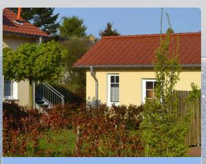 une maison jaune avec un toit rouge dans l'établissement Am Mühlenkamp daheim 7, 8, 14, à Heringsdorf