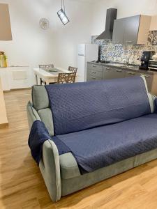 un divano con una coperta blu sopra una cucina di Joya house a Taranto