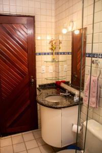 a bathroom with a sink and a toilet and a mirror at Apartamento a 400 metros da Praia do Frances-AL in Marechal Deodoro