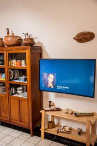 a living room with a flat screen tv and a cabinet at Apartamento a 400 metros da Praia do Frances-AL in Marechal Deodoro