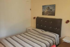Dormitorio pequeño con cama con cabecero negro en Departamento con kitchenet. Entrada independiente. en Córdoba