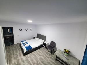 a small room with a bed and a table at Vila Paradis Costinesti in Schitul