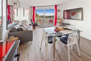 ein Wohnzimmer mit Tisch und Couch in der Unterkunft RÉSIDENCE ALCANTARA vue mer, première ligne in Saint-Brevin-les-Pins