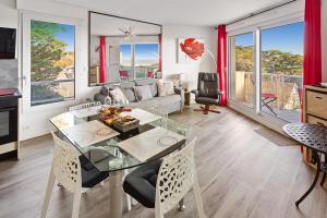 ein Wohnzimmer mit einem Glastisch und Stühlen in der Unterkunft RÉSIDENCE ALCANTARA vue mer, première ligne in Saint-Brevin-les-Pins