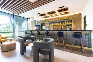 a restaurant with a bar with chairs and tables at Owen House by Habyt in Singapore