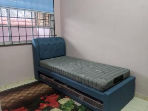 Kampong Kelemak的住宿－Aryani Homestay，窗户客房内的一张蓝色的床