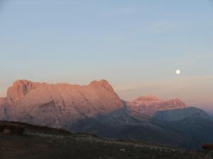 a view of mountains with the moon in the sky at Hotel Azola in Canazei