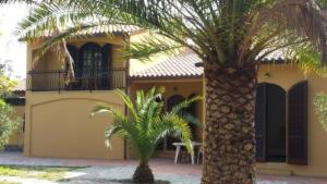 two palm trees in front of a house at Capoliveri: Villa Artistica app. 2/bilo4 (bilocale in Capoliveri