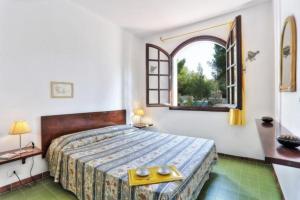 a bedroom with a large bed and a window at Capoliveri: Villa Artistica app. 2/bilo4 (bilocale in Capoliveri