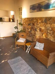 uma sala de estar com dois sofás e uma parede de pedra em Casa Dos Arcos Bed and Breakfast em Arraial do Cabo