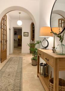a hallway with a mirror and a table with a lamp at La Place B&B in Sancerre