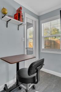 an office with a desk and a chair and windows at A Cottage - Walk to UC Davis & Shriners in Sacramento