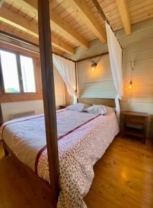 a bedroom with a canopy bed in a house at Le Chalet du Moulin in Brousses-et-Villaret